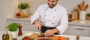 Chef preparing food on a Nolly Home premium bamboo cutting board in a kitchen